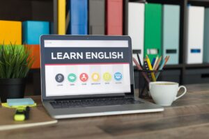 A laptop shows "Learn English" is set on a well organized table